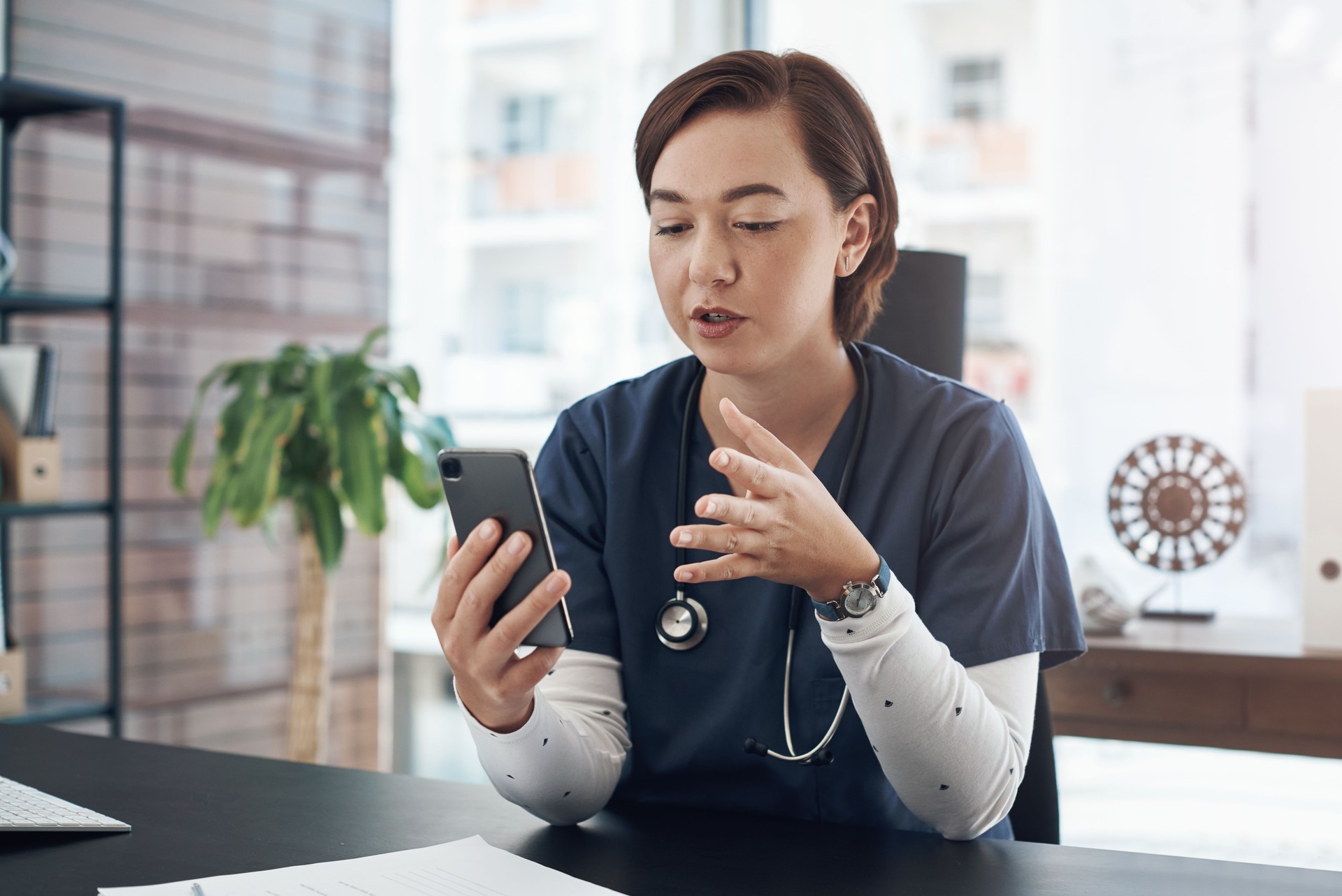 Shot of a young doctor using a cellphone in an office