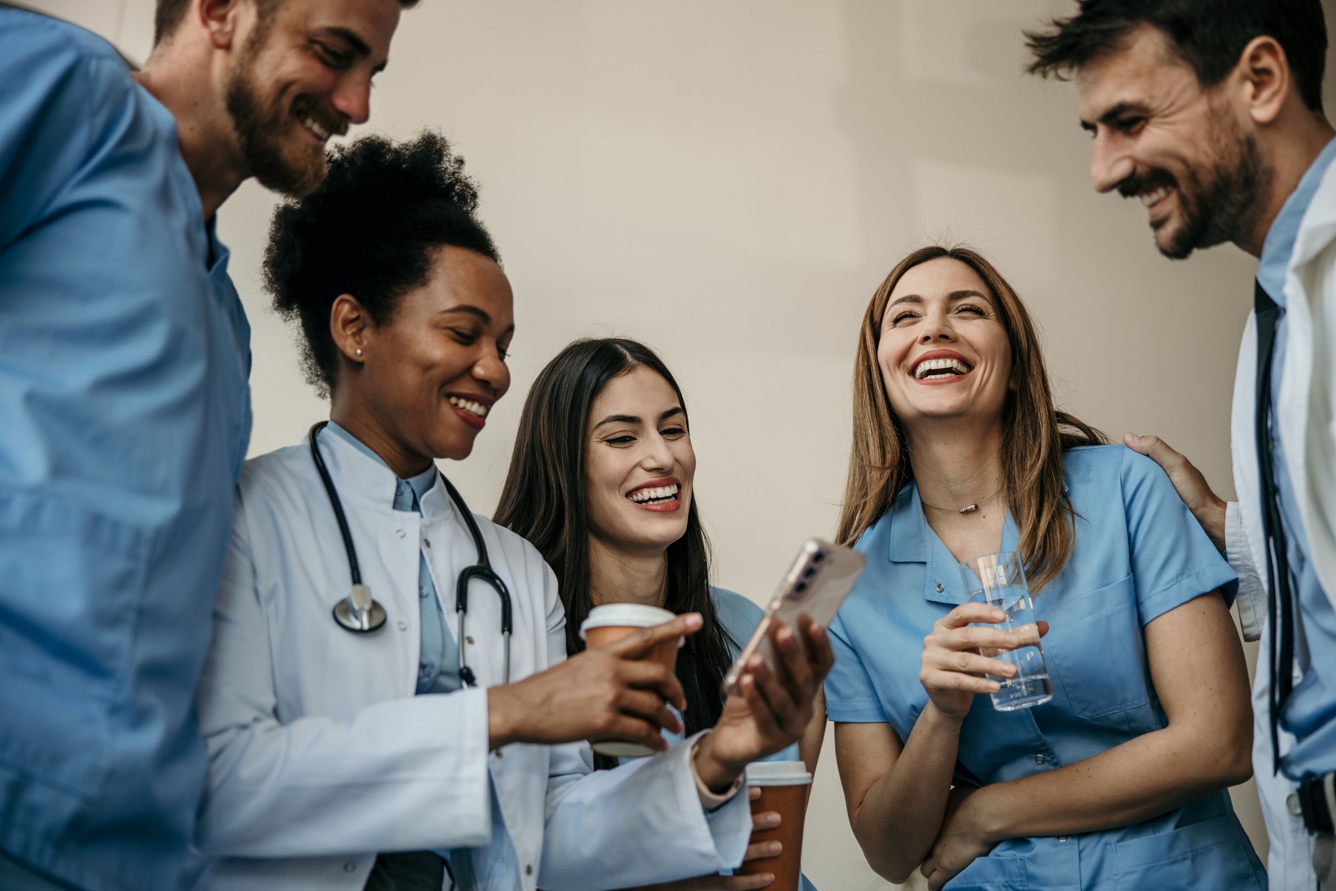 Doctors and nurses having a break around the smartphone